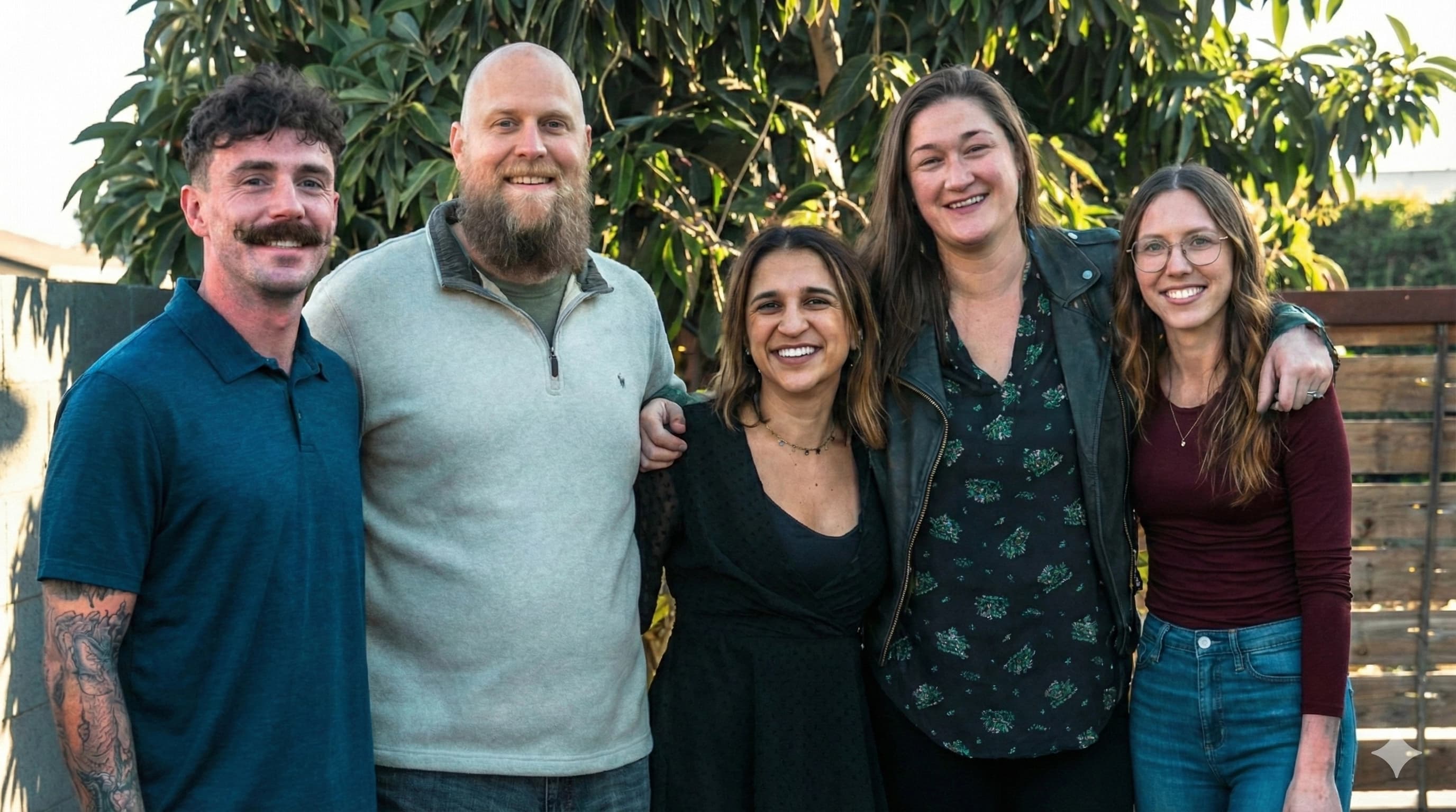 Five adults standing together outdoors